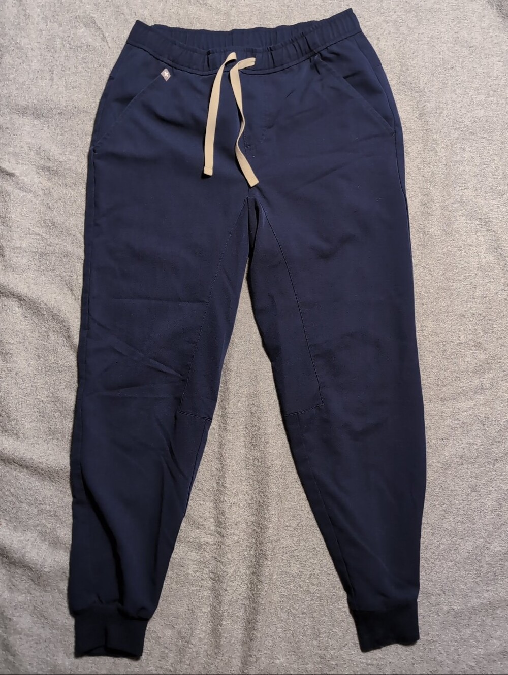 FIGS Tilden jogger scrub pants in navy blue. Features an elastic waistband